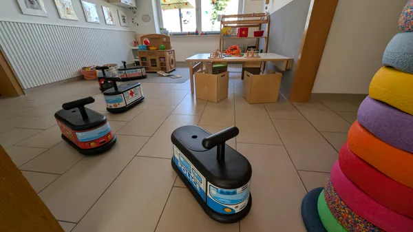 Spielzimmer mit Rutschautos und Fahrzeugen für motorische Entwicklung und Bewegungsspiele