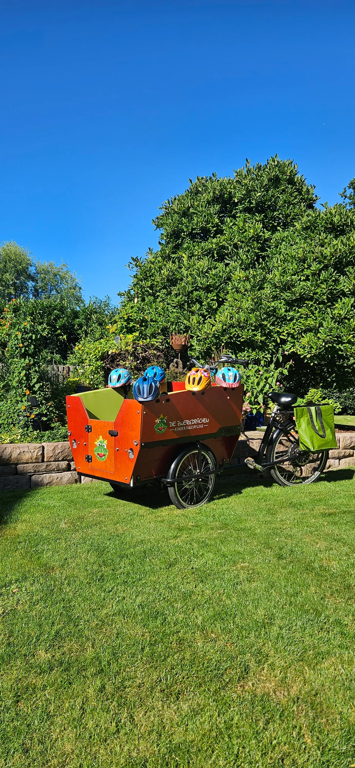 Lastenrad im Garten mit Kinderhelmen – Sichere Ausflüge und Mobilität in der Kindertagespflege Die Zwergdrachen