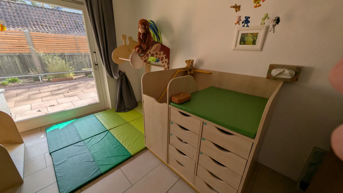 Sichere Wickelstation mit gepolsterten Matten und kindgerechten Kletterelementen für sanfte Eingewöhnung