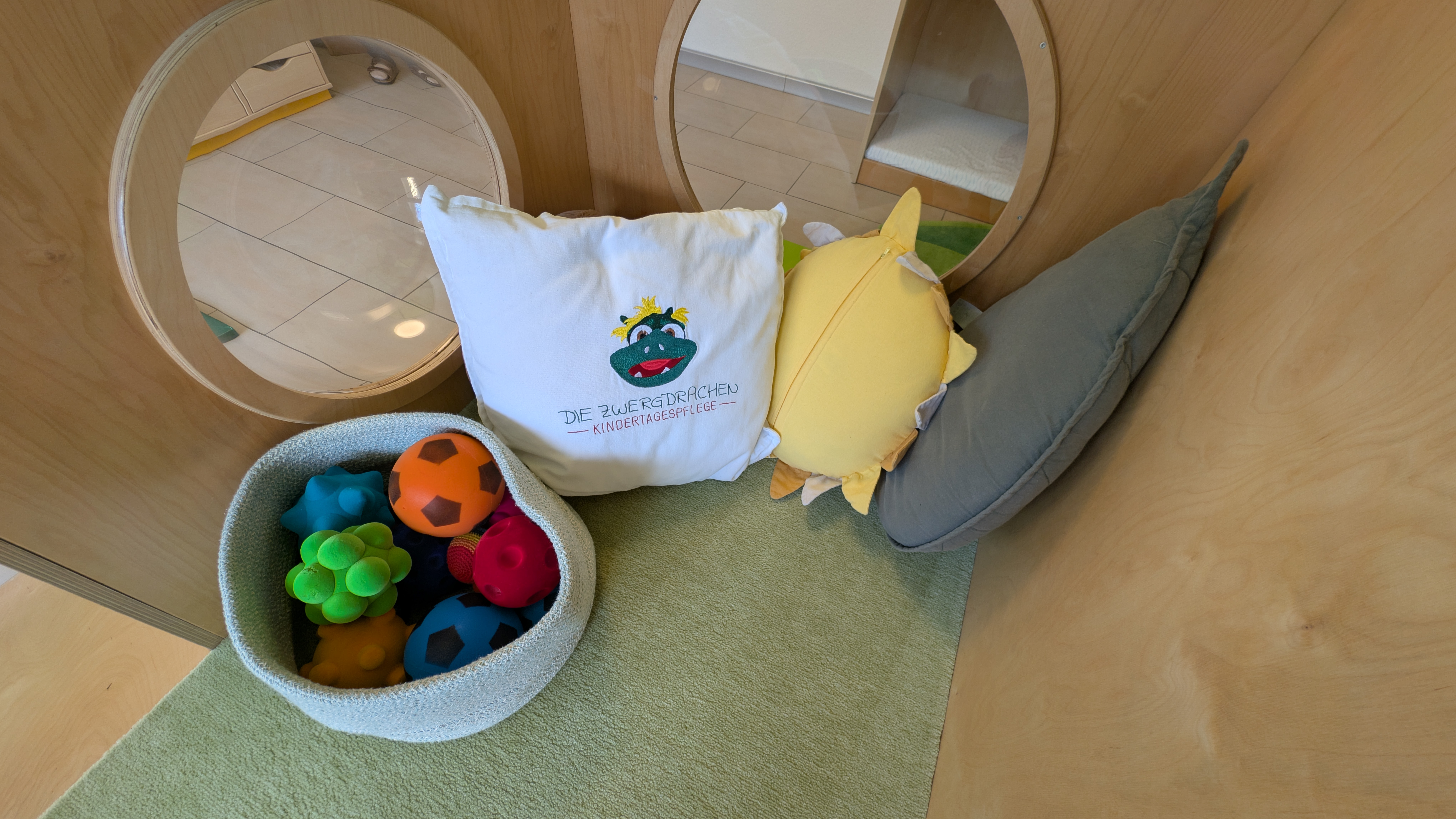 Gemütliche Spielecke mit Kissen und Sensorikspielen für entwicklungsfördernde Aktivitäten nach Marte Meo Prinzipien
