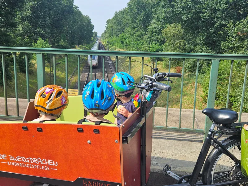 Kinder beim gemeinsamen Ausflug mit dem Krippenfahrrad – täglich draußen unterwegs