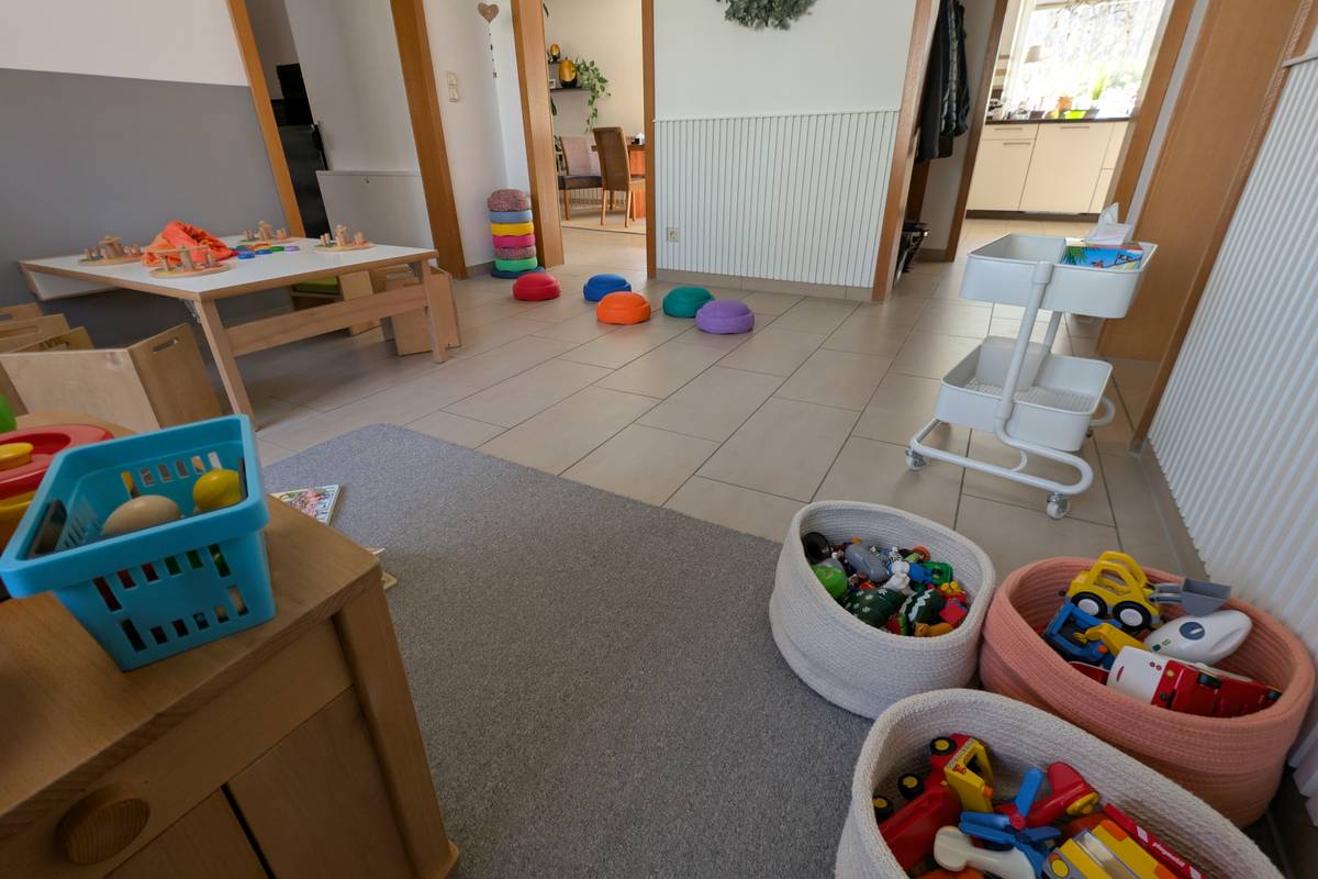 Organisierter Spielbereich mit zugänglichen Aufbewahrungskörben, Bewegungsparcours und kindgerechten Möbeln