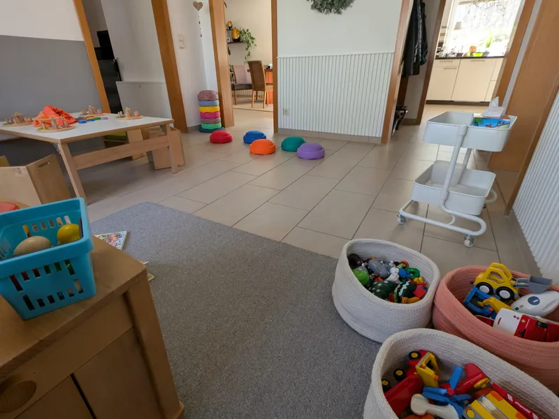 Organisierter Spielbereich mit zugänglichen Materialien und Bewegungselementen für selbstbestimmtes Spielen und Lernen