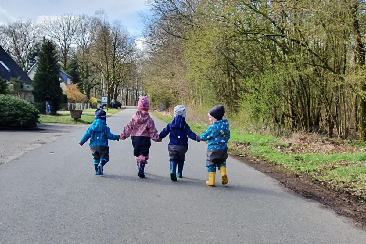 Vier Kinder Hand in Hand beim Spaziergang – Gemeinschaft und soziale Entwicklung in der Kindertagespflege Die Zwergdrachen